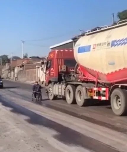 老人坐轮椅马路上拦货车要钱 当地工作人员:没法处理